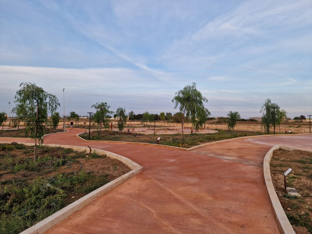 I vialetti del parco tra aiuole e giovani alberi